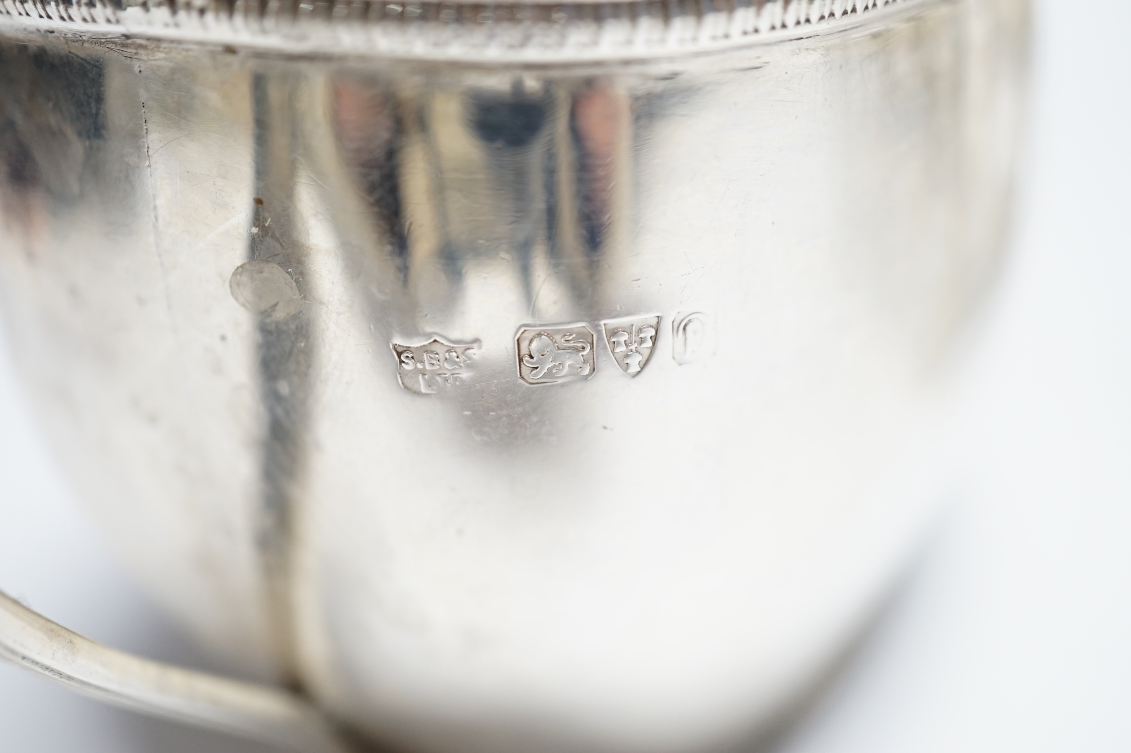 A George III engraved silver cream jug, London, 1808, height 82m, a George V silver cream jug and matching sugar bowl, and a George V silver five bar toast rack, 15.4oz.